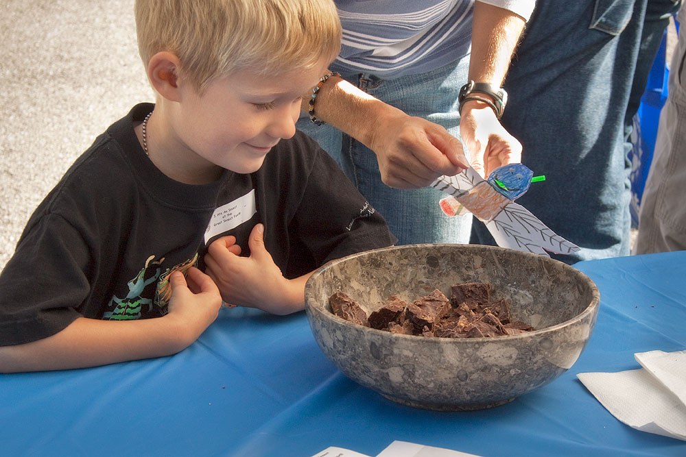 Nicholas gets a second helping of "chocolate chirpies" (chocolate covered crickets) at the Insect Deli. Photo by Nick Sloff