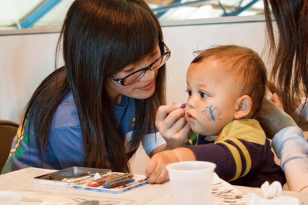Rynji get his face painted by Zenglei. Photo by Nick Sloff