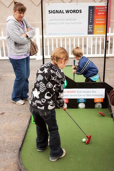 A family enjoys a round of mini golf at the Integrated Pest Management/Pesticide Safety Putt Putt course. Photograph by Nick Sloff
